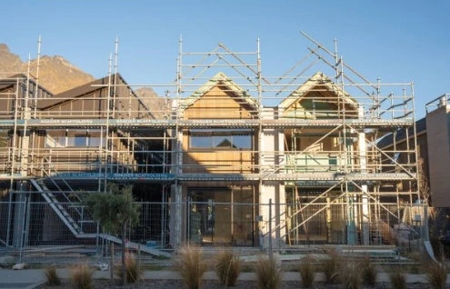 Construcción de viviendas unifamiliares con estructuras de andamios metálicos y fachadas de madera en Barcelona