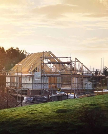 Construcción de vivienda unifamiliar con estructura de vigas de madera y andamios perimetrales en Barcelona
