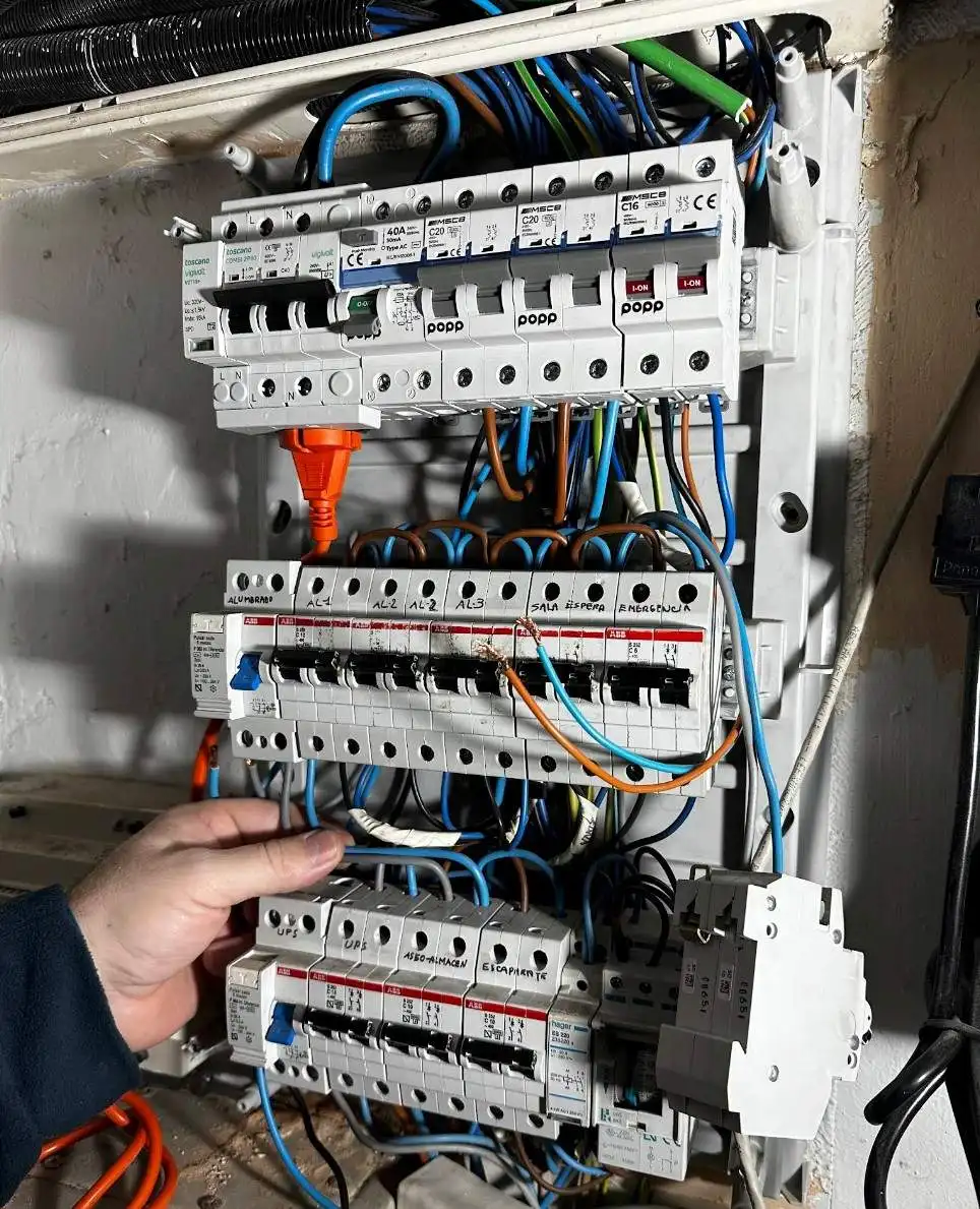 Instalación de electricidad con operario manipulando el cableado de un cuadro eléctrico en Barcelona